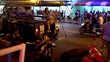 a woman sits in a thai taxi