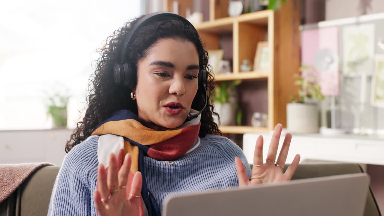 Žena se sluchátky na videohovoru doma