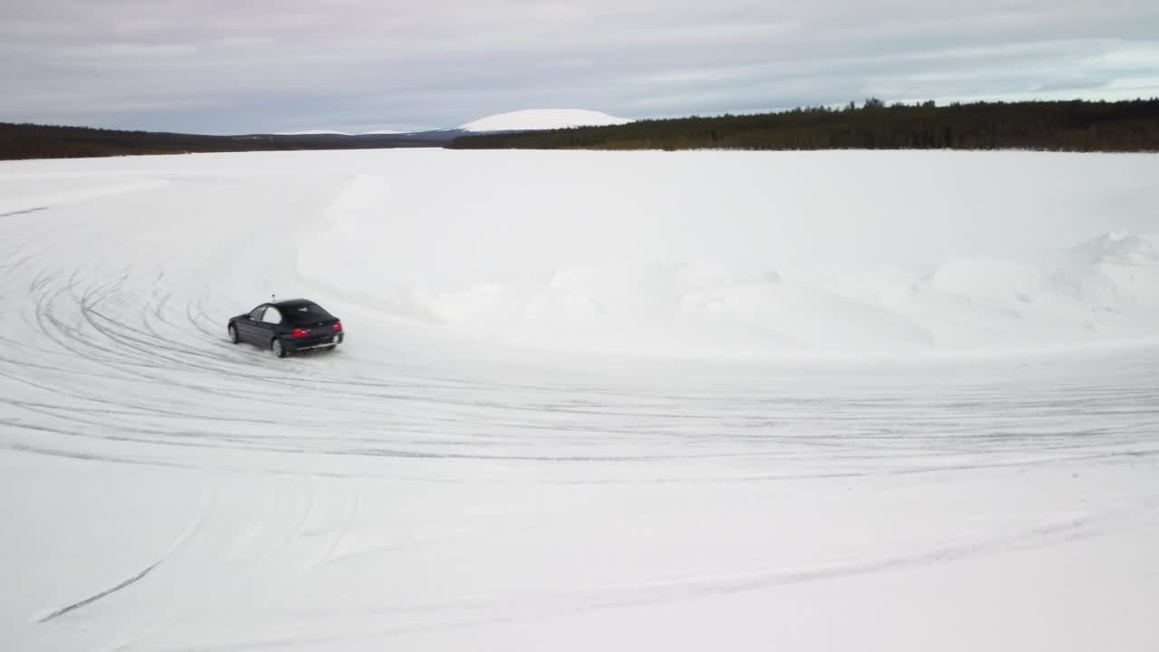 To sportsvogne drifter på en frossen sø i Finland – Luftfoto af vinterlandskab med et frossent racerbanespor.