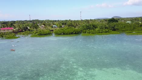 Aerial-view-flying-with-drone-over-tropical-ocean-and-mangroves-towards-land