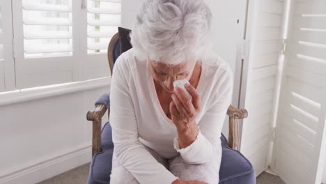 senior african american woman crying and weeping tears with tissue at home