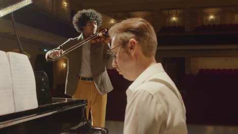 musicians playing piano and violin on stage