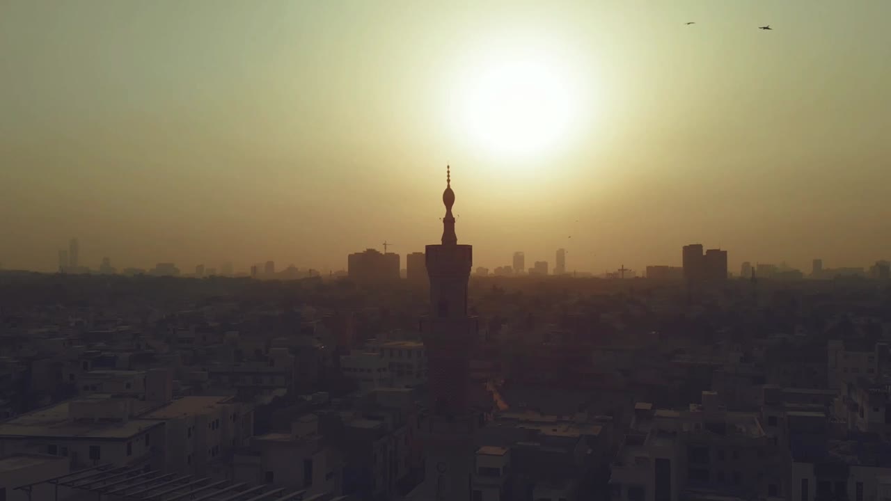 vista aérea de la silueta del minarete de la mezquita en karachi contra el cielo amarillo del atardecer