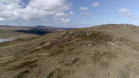 Rising-aerial-above-a-moorland-hill-revealing-a-large-body-of-water-known-as-the-Kyle-of-Tongue