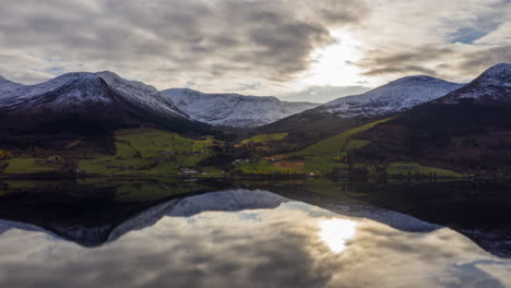 Perfect-reflection-of-mountains-and-sun-in-a-crystal-clear-lake-in-Norway