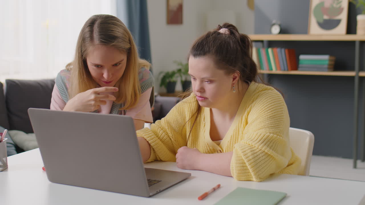 Girl with Down Syndrome and Female Tutor Using Laptop and Talking