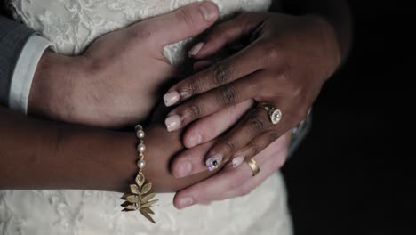 close up of a interracial couple hands as they cuddle for the photographer at night