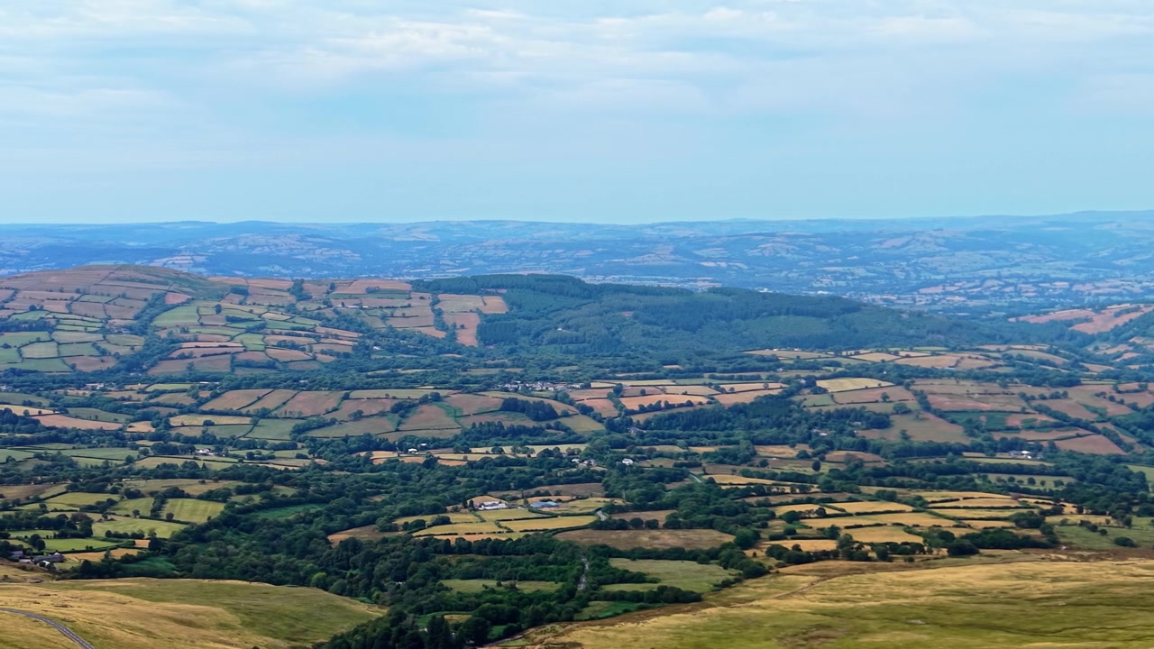 Høyt vinkelbilde av solbakte jorder i Wales, Storbritannia. Fremhever tørr jord, uttørkede beitemarker, skadede avlinger som følge av langvarige hetebølger og ekstremvær.