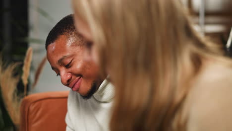 black man looks at white girlfriend showing family album