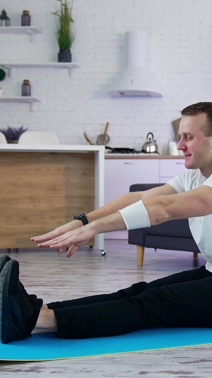 Strong man on quarantine working out in home. Young athletic healthy male training indoors