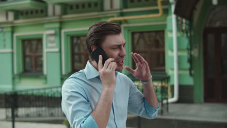 businessman having talk on mobile phone. man talking phone in shirt at street