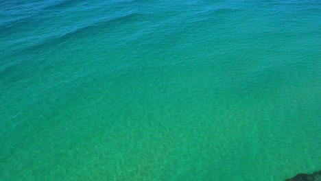 vuelo ascendente hacia el horizonte del mar azul y turquesa de la costa cantábrica con el cielo con nubes blancas en la distancia en un soleado día de verano en la zona turística cantábria españa