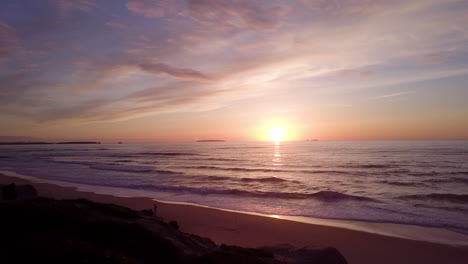 sunset over the beach with a silhouette of a person fishing