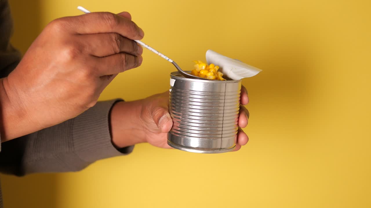 Maíz enlatado sobre fondo amarillo