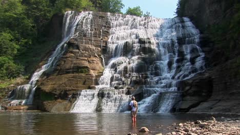 a wide waterfall flows over rock ledges in ithaca falls new york 7