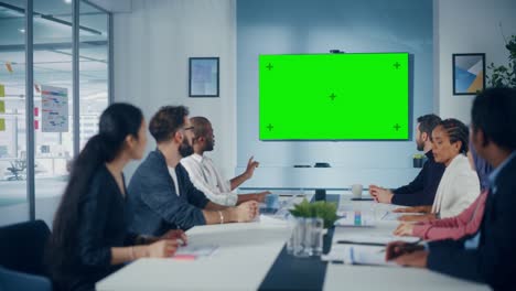 multi-ethnic office conference room meeting: diverse team of successful managers, executives talk, use green screen chroma key tv. businesspeople investing in e-commerce startup