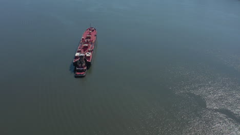 a drone view of a large red barge anchored in the hudson river in ny on a sunny day