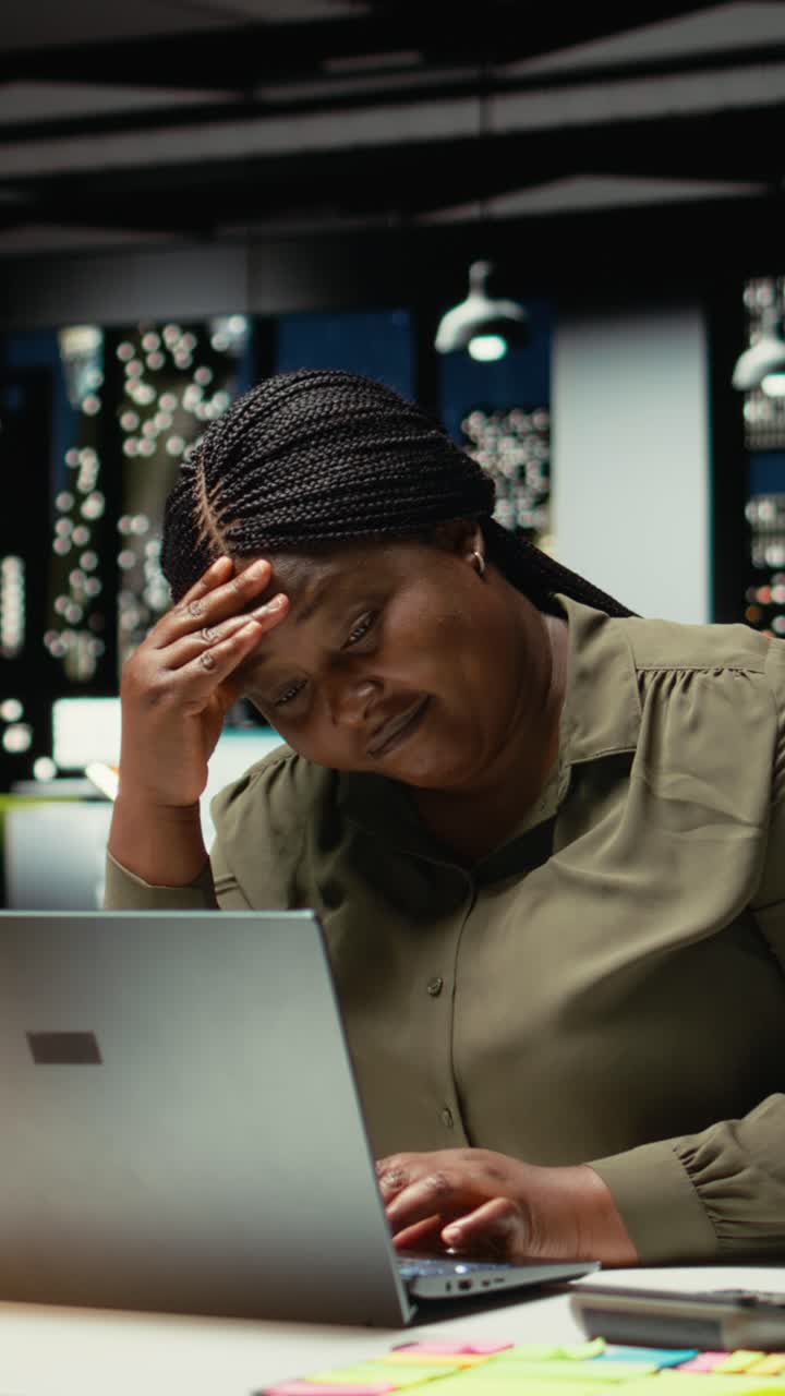 Vertical Video Troubled overworked woman sighing after realizing the late hour