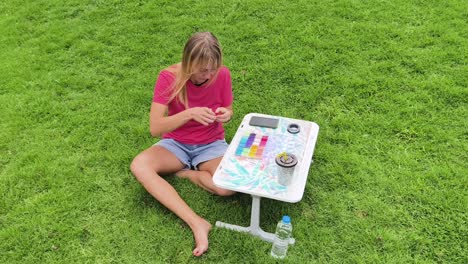 mujer con cuentas al aire libre en una mesa portátil