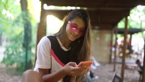 young woman texting on phone in park