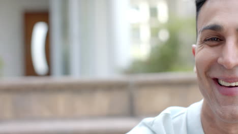 medio retrato de un feliz hombre biracial sonriendo en un jardín soleado, espacio de copia, cámara lenta