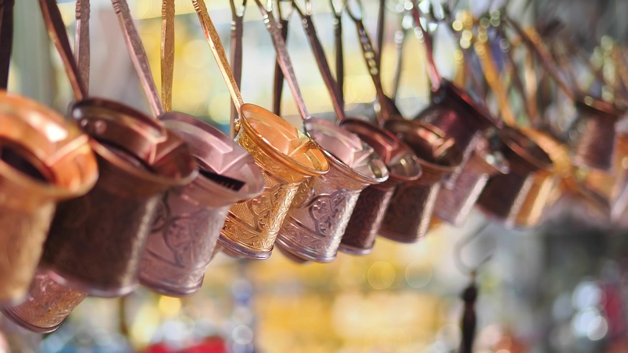 Row of Traditional Copper Turkish Coffee Pots Hanging in a Market