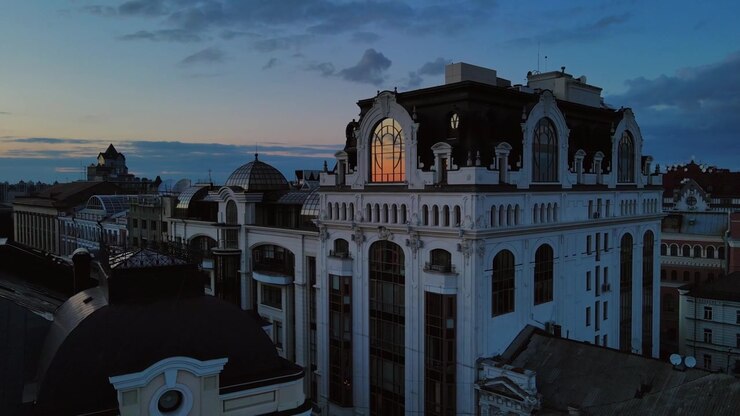 Facciata mansardata ad arco illuminata di un palazzo storico decorato a Kiev, Ucraina