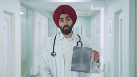sad sikh indian doctor explaining x ray report to patient