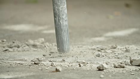 close-up of excavator hydraulic arm rock breaker working on concrete road
