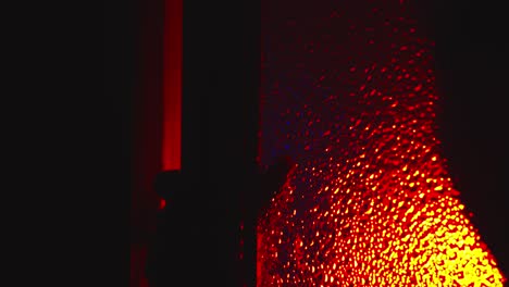 una silueta siniestra y aterradora se arrastra, abre la puerta de vidrio bajo la luz roja