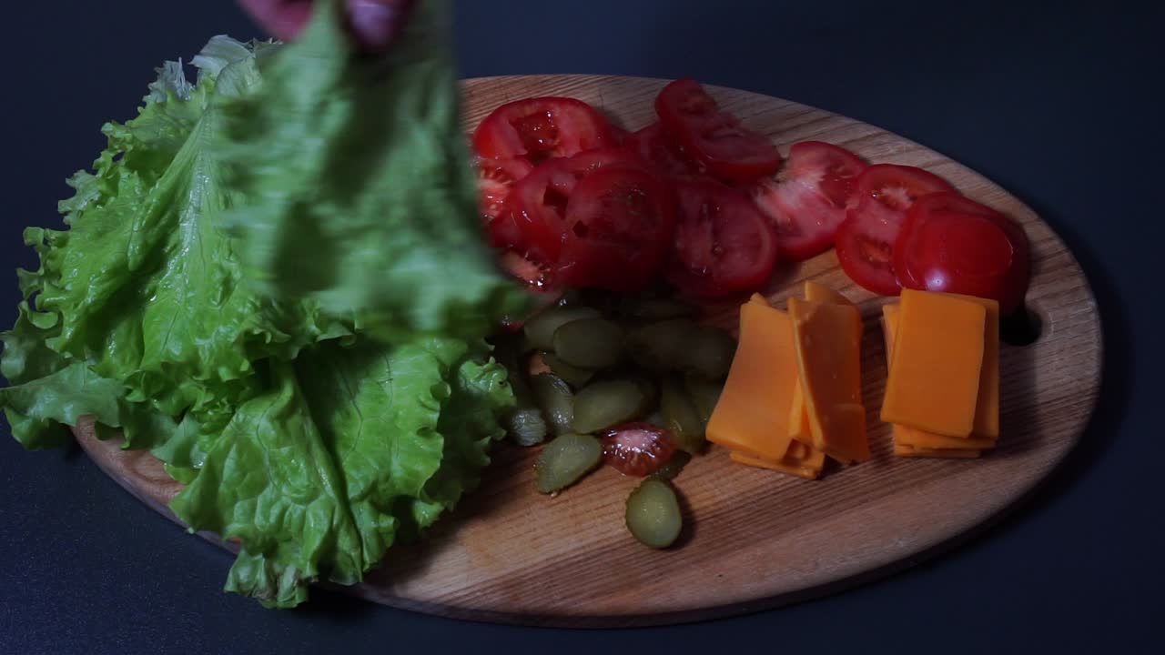 preparando lentamente un plato de ensalada en una tabla de madera