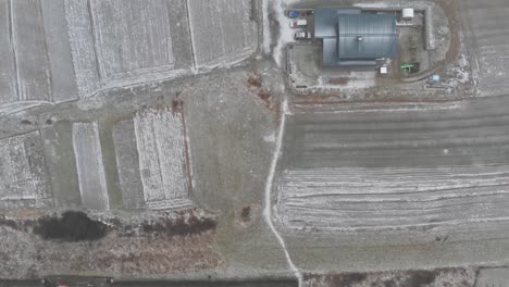 Top-down-overhear-Aerial-over-residential-area-and-fields-with-light-cover-of-snow