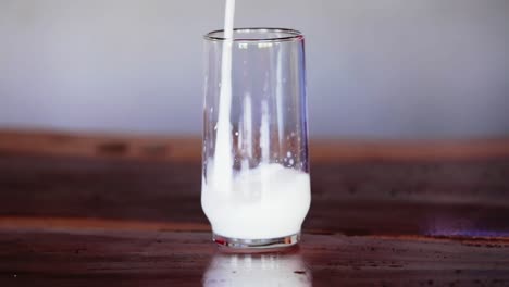 la leche se vierte en un vaso sobre la mesa