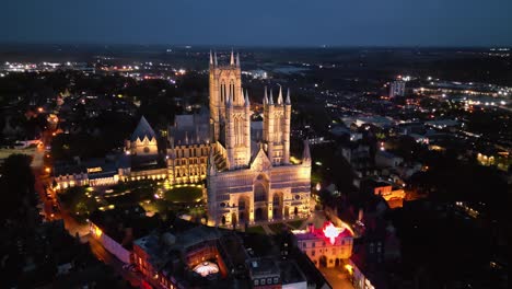 drone video showcases lincoln cathedral in lincolnshire, uk, at dusk, emphasizing its majestic gothic architecture with illumination