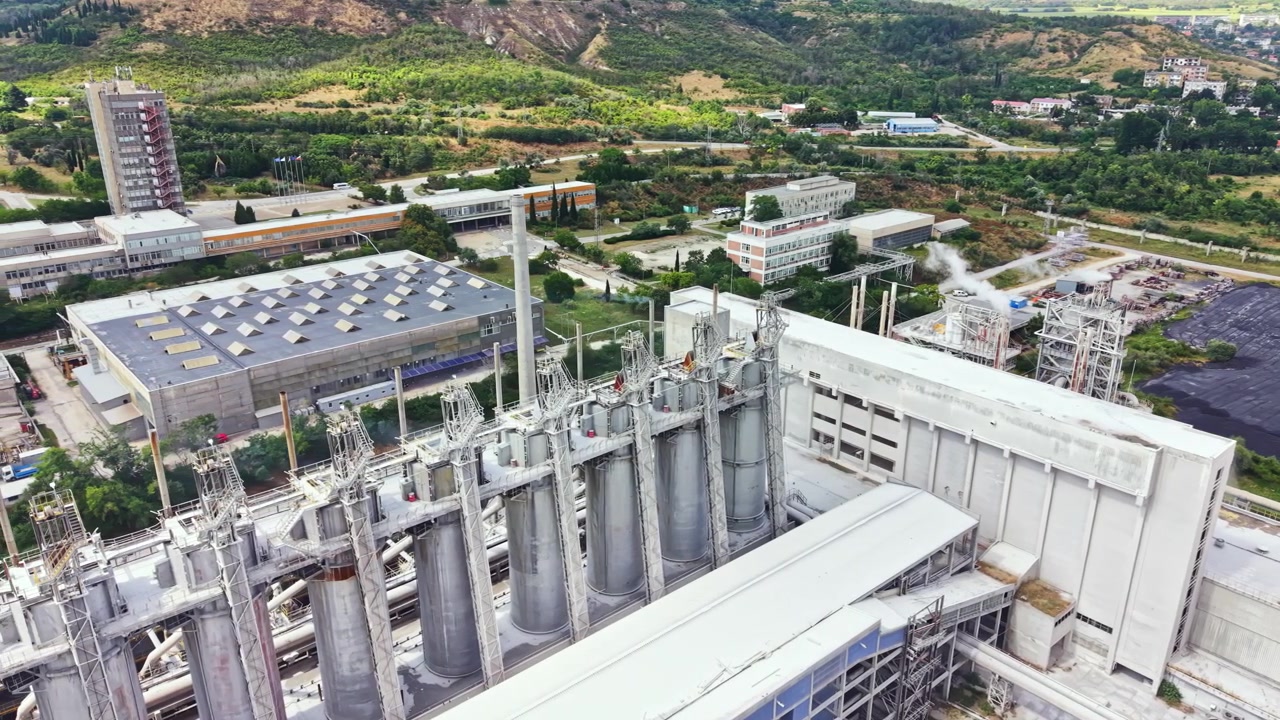 Vista de un área industrial con edificios y equipos en una región montañosa durante el día