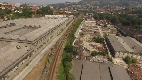 ferrocarril rodeado de fábrica abandonada