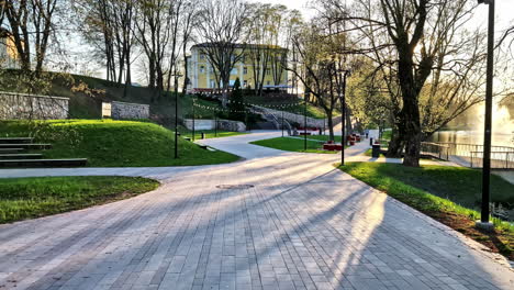 pathway through valmiera city park with sunlight and spring trees