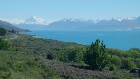 spectacular mount cook standing tall, framed by a pristine lake in a captivating natural tableau