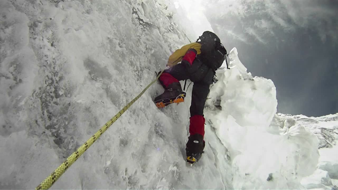 바람과 눈이 부는 얼음 벽에 산악인