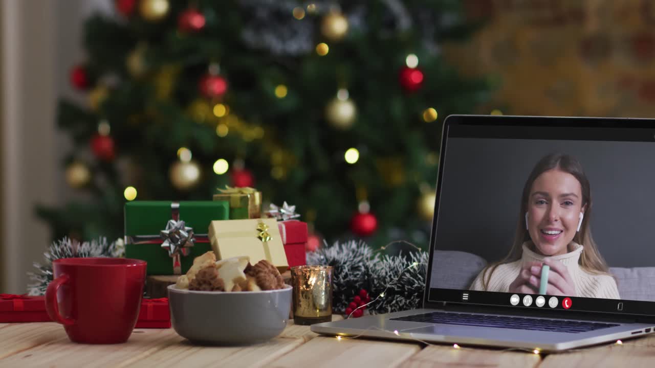 mujer caucásica feliz en videollamada en computadora portátil, con decoraciones de navidad y árbol