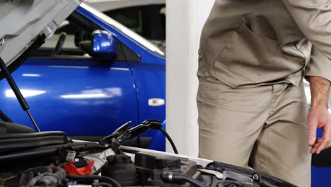 mecánico que conecta los cables de arranque a la batería del coche