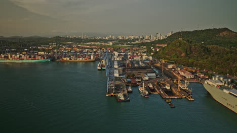 panama city aerial v46 panning view capturing port of balboa large container terminal and shipyard with ancon hill and cityscape in the background at sunset - shot with mavic 3 cine - march 2022