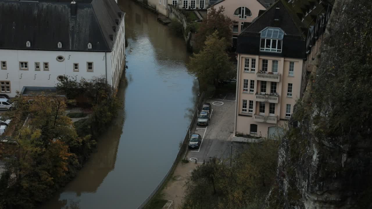 Vista di un tranquillo canale cittadino con edifici storici e alberi autunnali