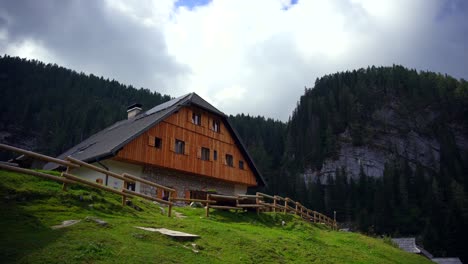 footage filmed of a big house surrounded by mountains in nature up in the alps, filmed with a camera on a gimble in 4k