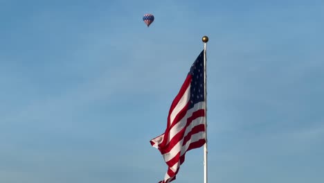 Enormous-American-flag-swaying-against-blue-sky-backdrop