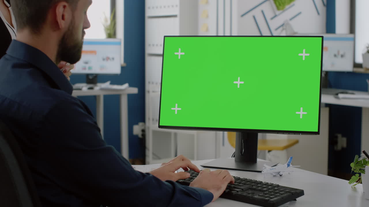 Close up of computer with horizontal green screen on desk