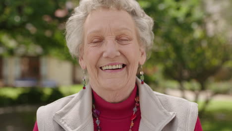 Porträt-Einer-älteren-Kaukasischen-Frau,-Die-Glücklich-Lächelt-Und-Im-Gartenhintergrund-In-Die-Kamera-Blickt