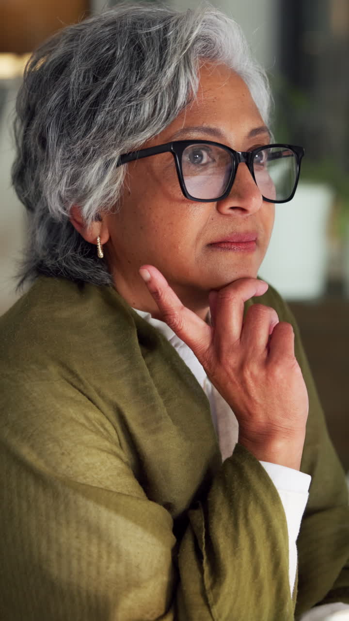 Thoughtful Senior Woman with Glasses Working Indoors