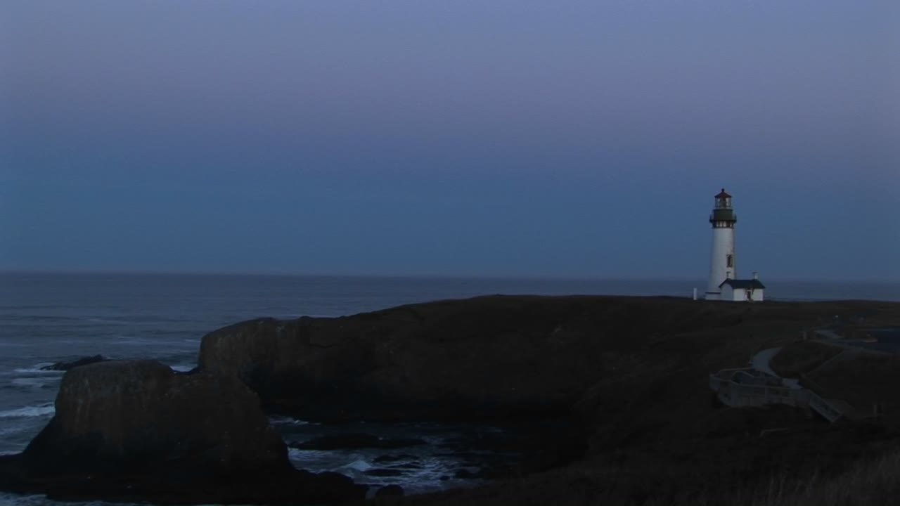 선원들에게 경고를 알리는 신호등이 있는 하얀 등대의 롱샷