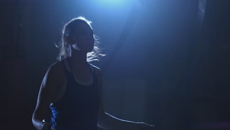 young beautiful woman boxer in training in the hall jumping rope medium size